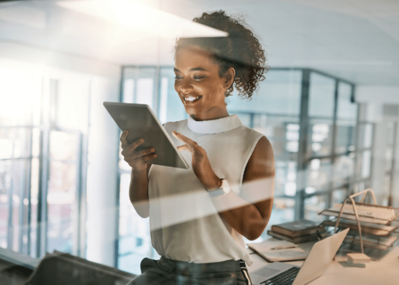 Professional woman sitting on a desk working on a tablet 