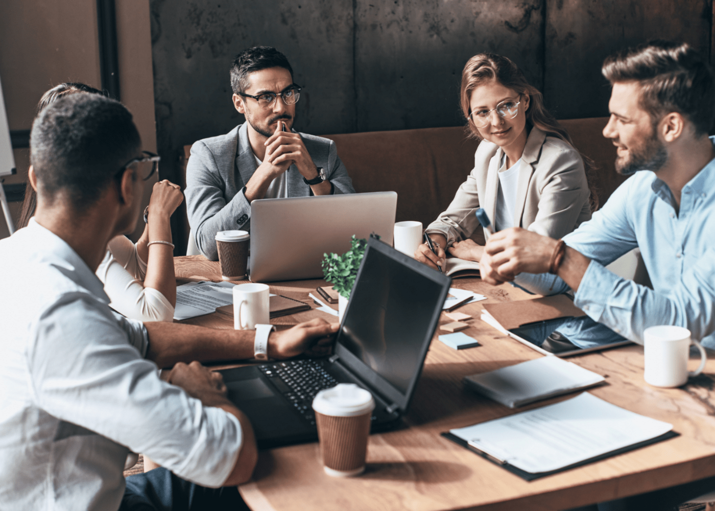 A group of business professionals engaged in a meeting actively discussing a topic