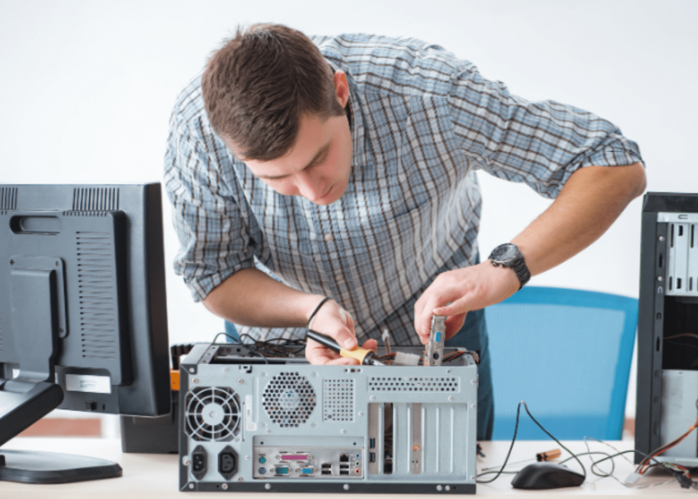 IT technician working on fixing a laptop and other peripherals 