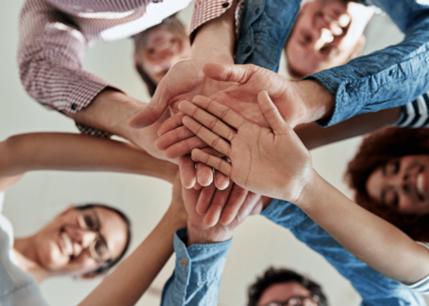 Business people with their hands in the center symbolizing motivation and a "go get it" energy 