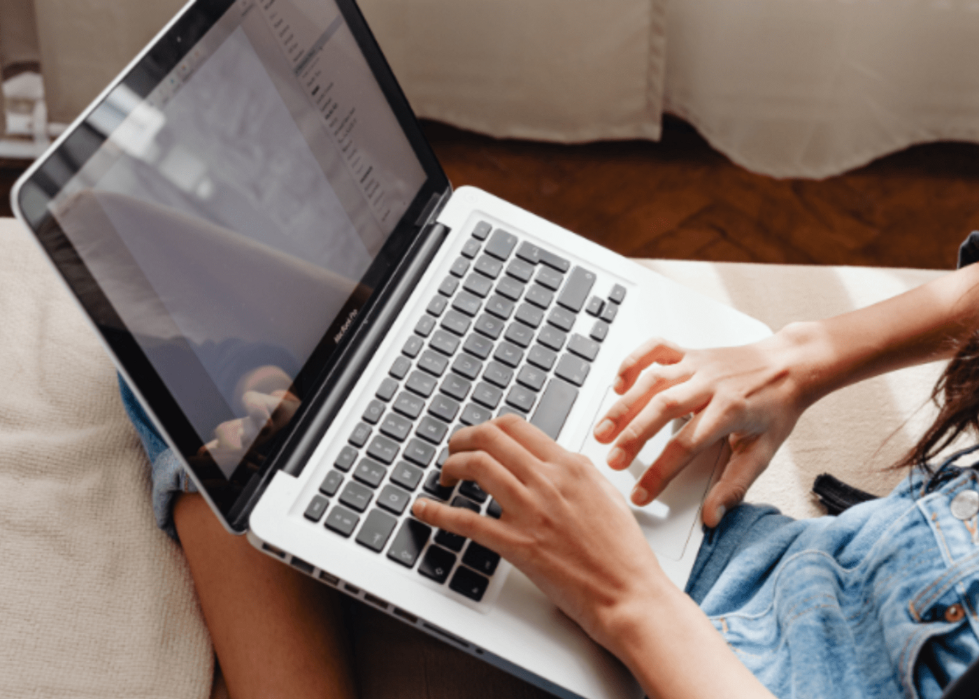  A woman focused on her work, typing on a laptop computer with determination and concentration.