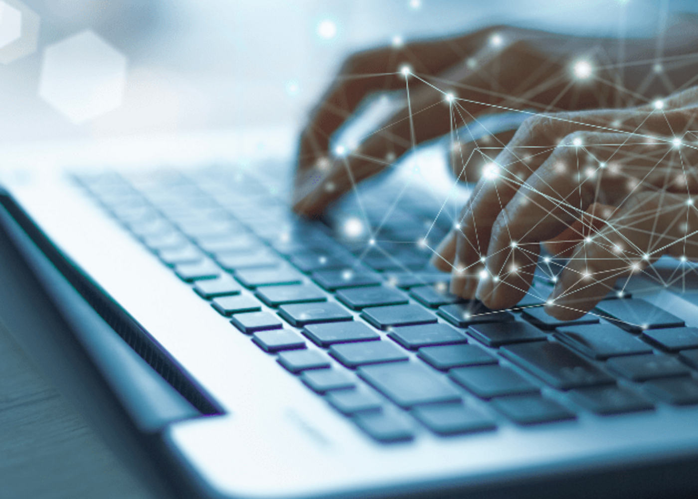 Two hands typing on a laptop key board with a technological and abstract visual effect